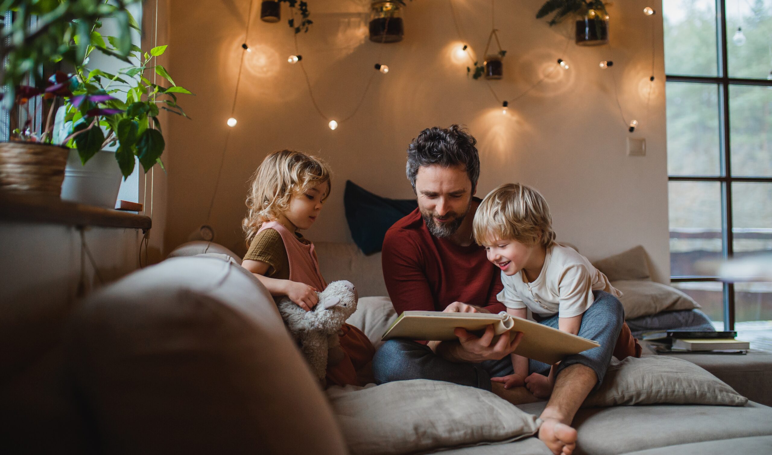 Mature Father with Two Small Children Resting Indoors at Home